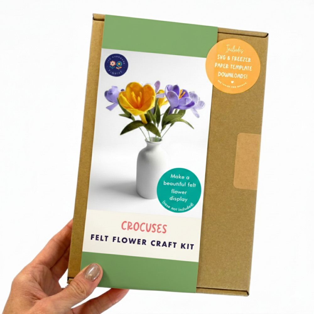 Hand holding a felt flower craft kit packaging with crocuses design.