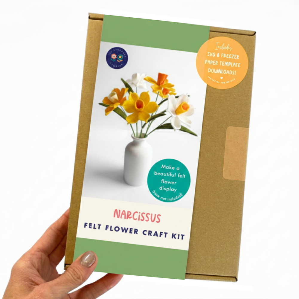 Felt flower craft kit packaging with a hand holding it, featuring narcissus flowers.