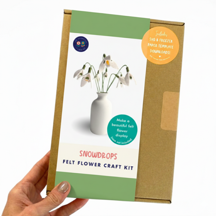 Snowdrops felt flower craft kit packaging held by a hand on a white background